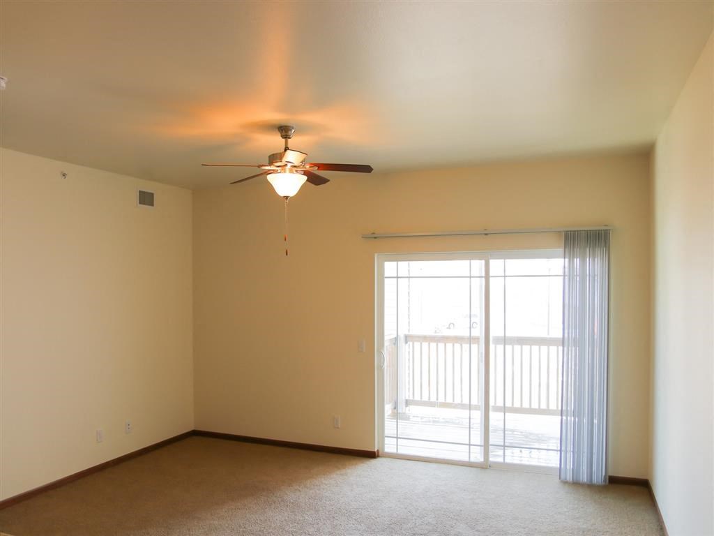 a bedroom with a ceiling fan and a sliding glass door