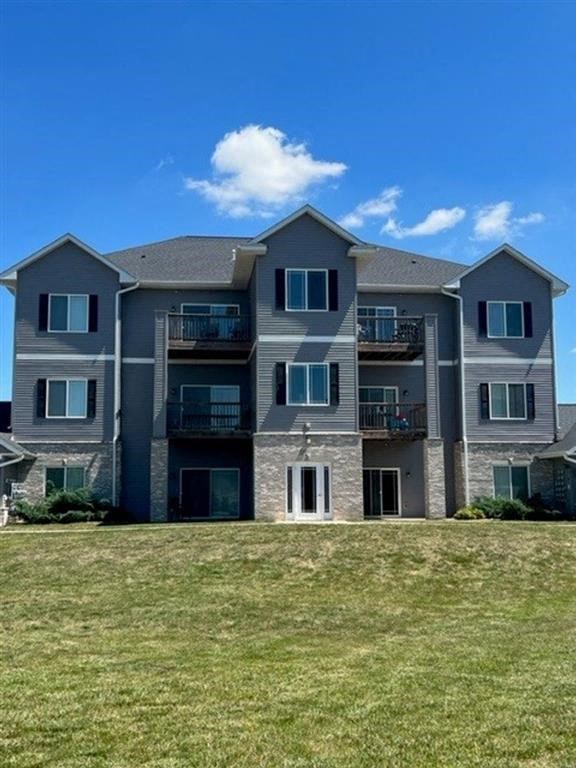 a large apartment building with a grassy area in front of it
