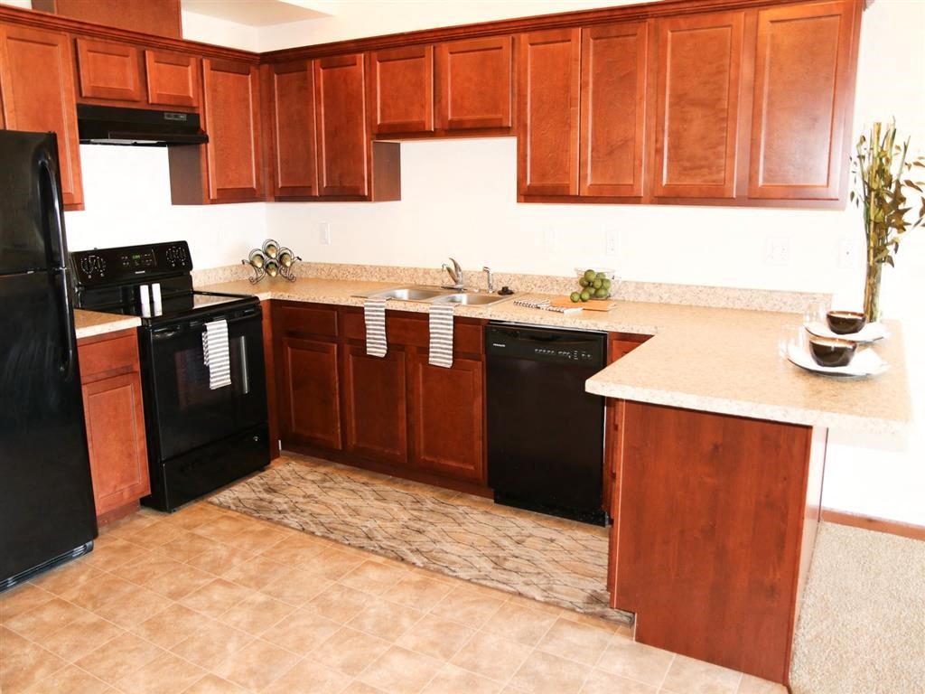 a kitchen with wooden cabinets and black appliances