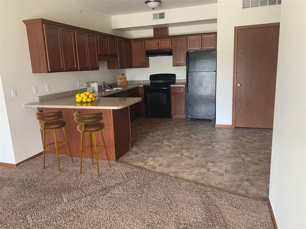a kitchen with a counter and three stools