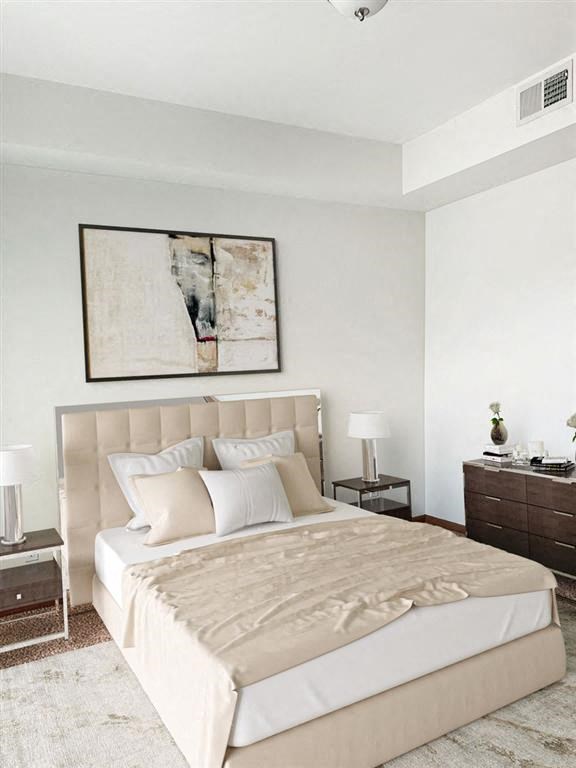 a bedroom with a large bed and a painting on the wall