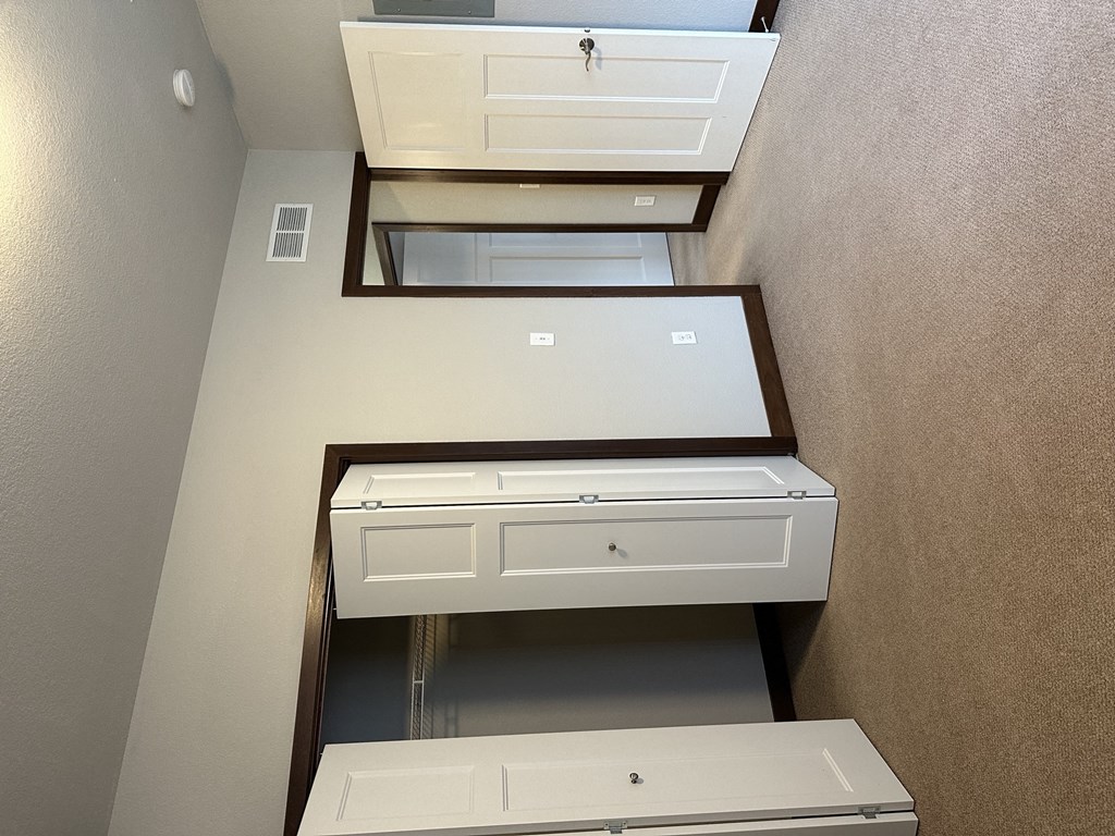 an overhead view of an empty closet with three drawers and a door