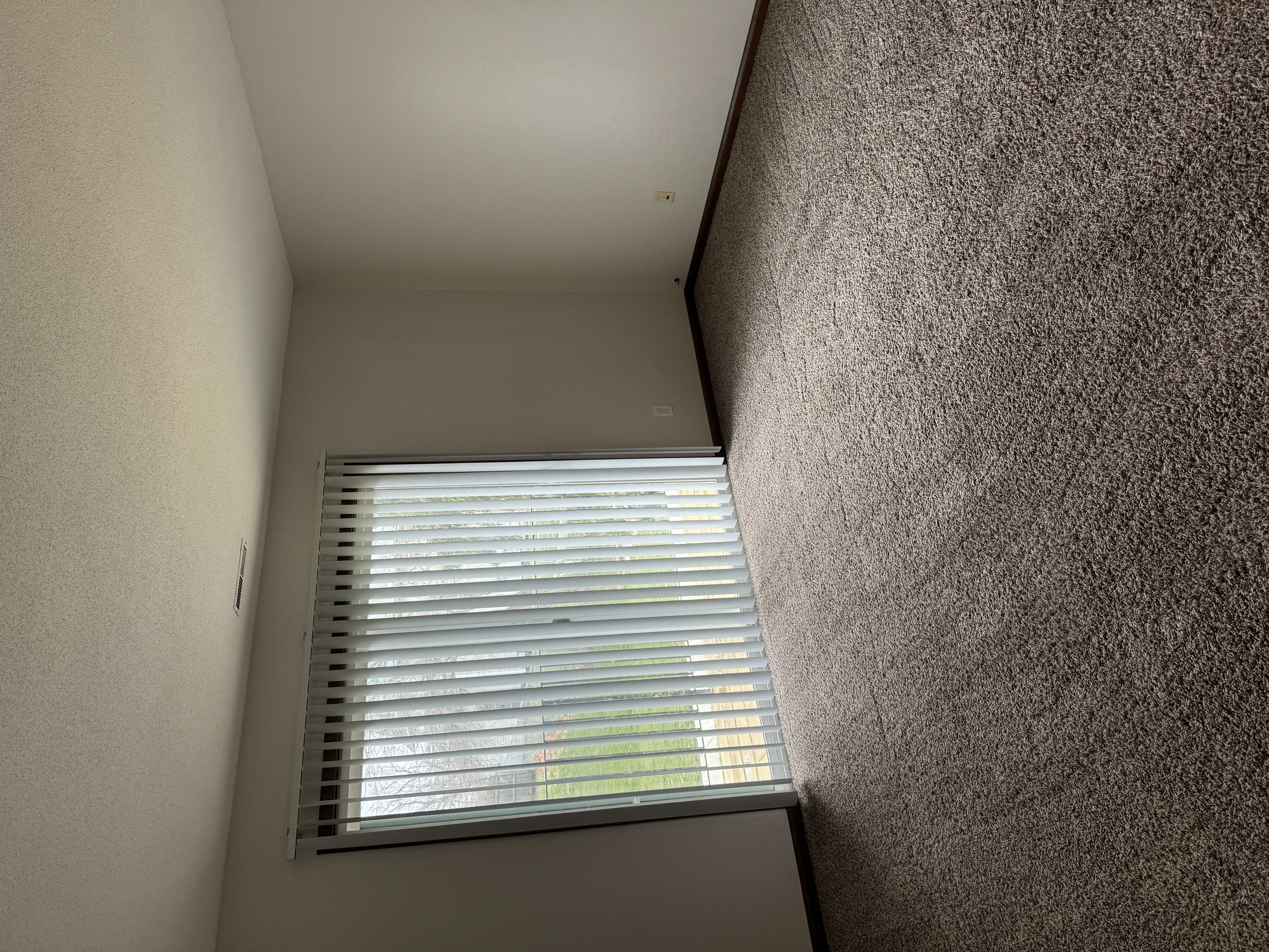 a window in a small room with a wall and a ceiling with a window