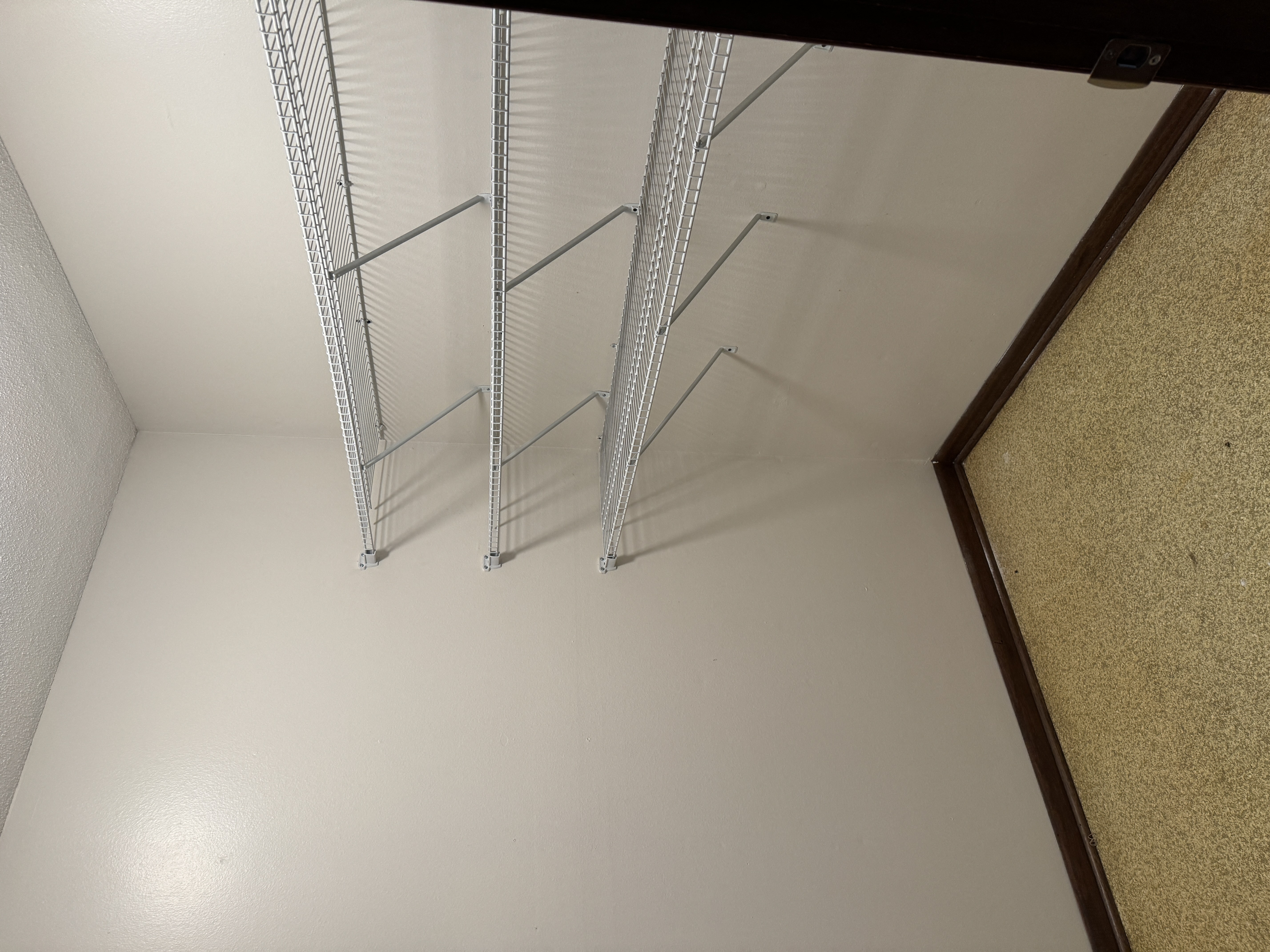 a room with white walls and metal shelves on the floor