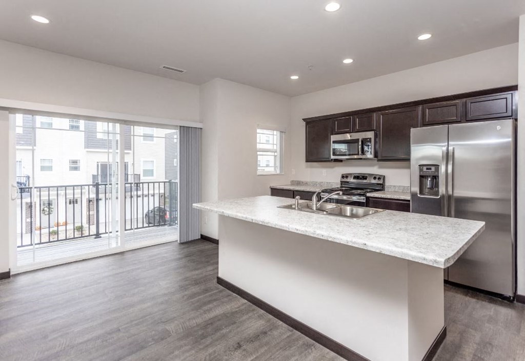 a kitchen with a counter top and a stainless steel refrigerator