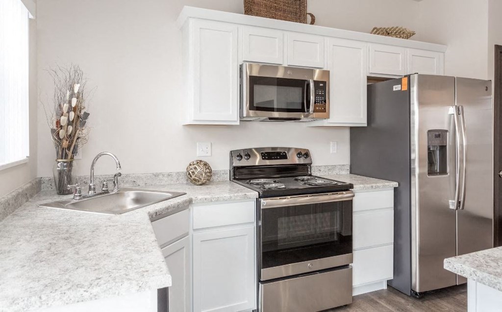 a kitchen with stainless steel appliances and white cabinets