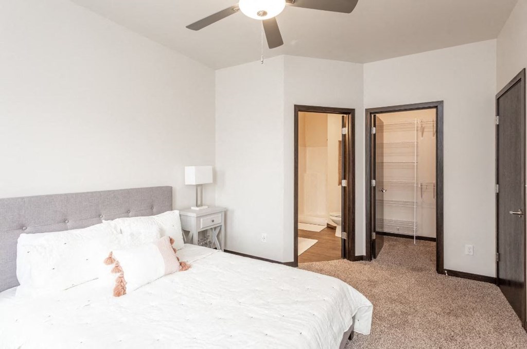 a bedroom with a large bed and a ceiling fan