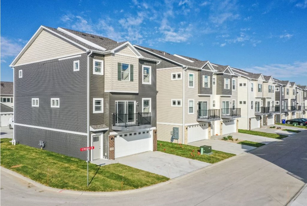 a row of condominiums on the side of a street