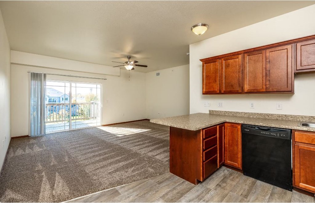 a kitchen and living room with a ceiling fan