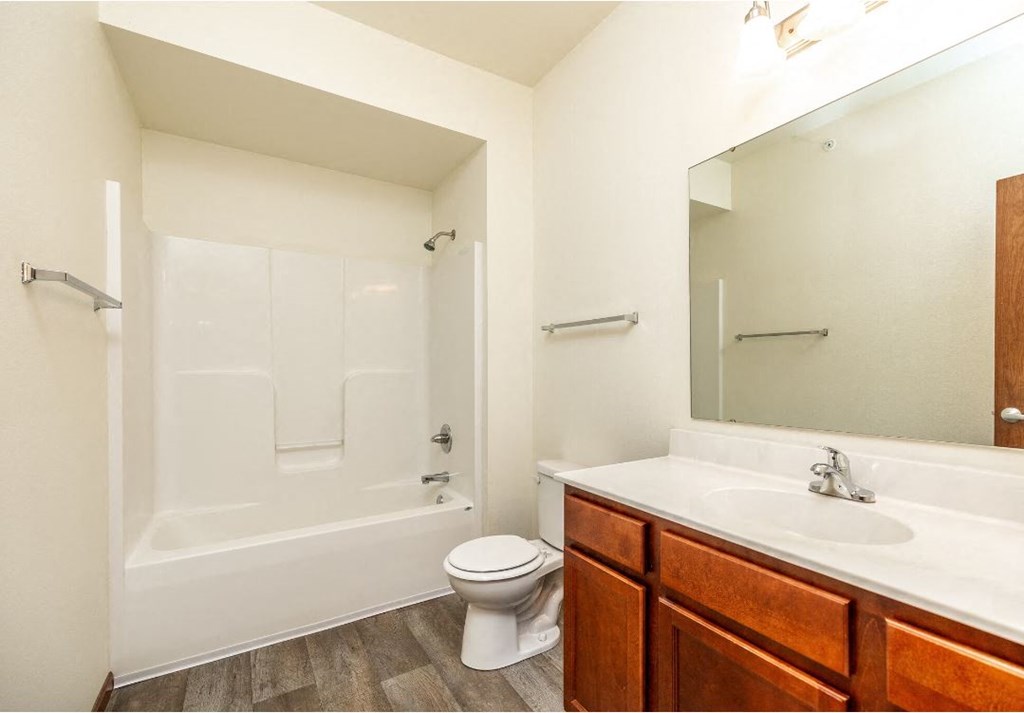 a bathroom with a large mirror and a toilet and a sink