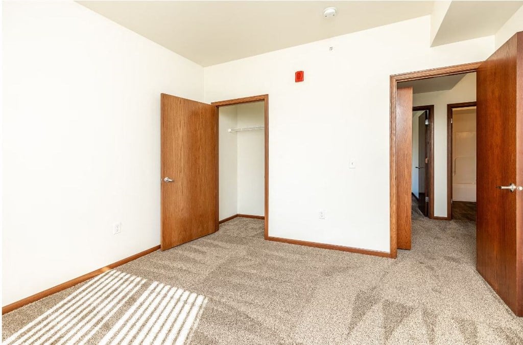 a room with a carpeted floor and two doors