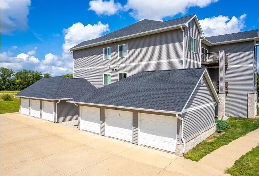 a garage with three garage doors in front of a house