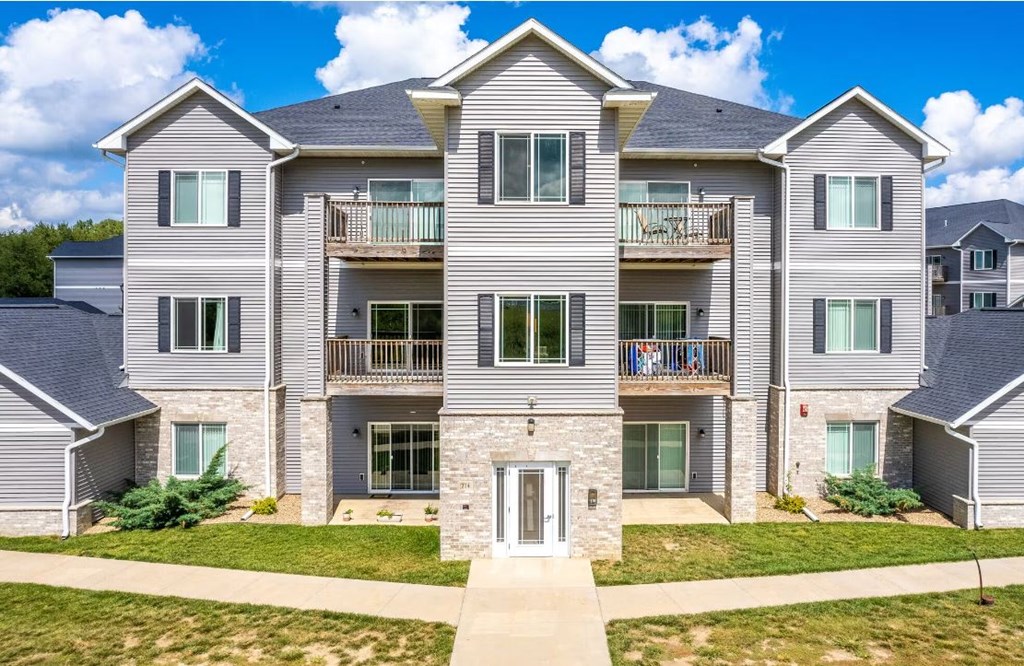 an apartment building with a sidewalk in front of it