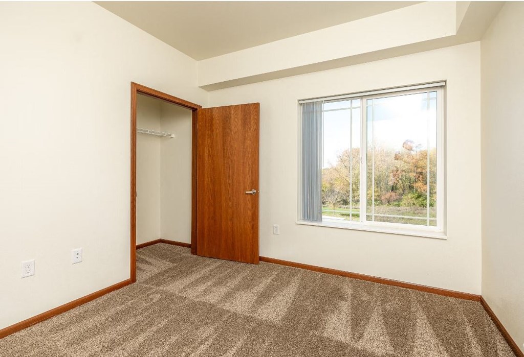 a room with a window and a door and a closet