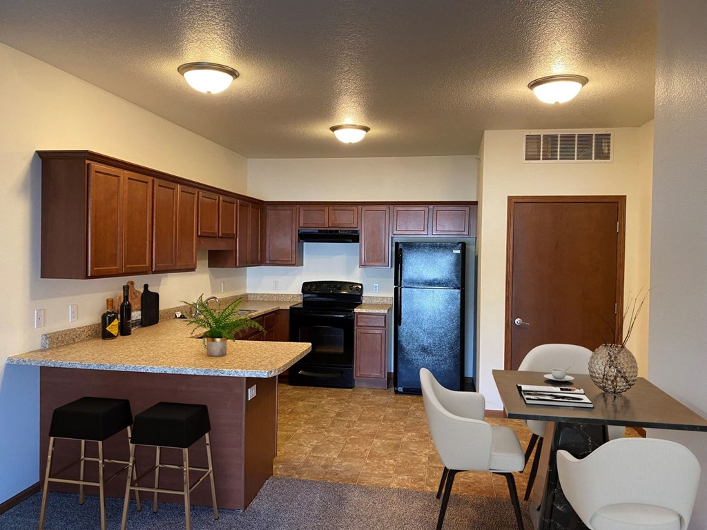 a kitchen with a breakfast bar and a table with chairs