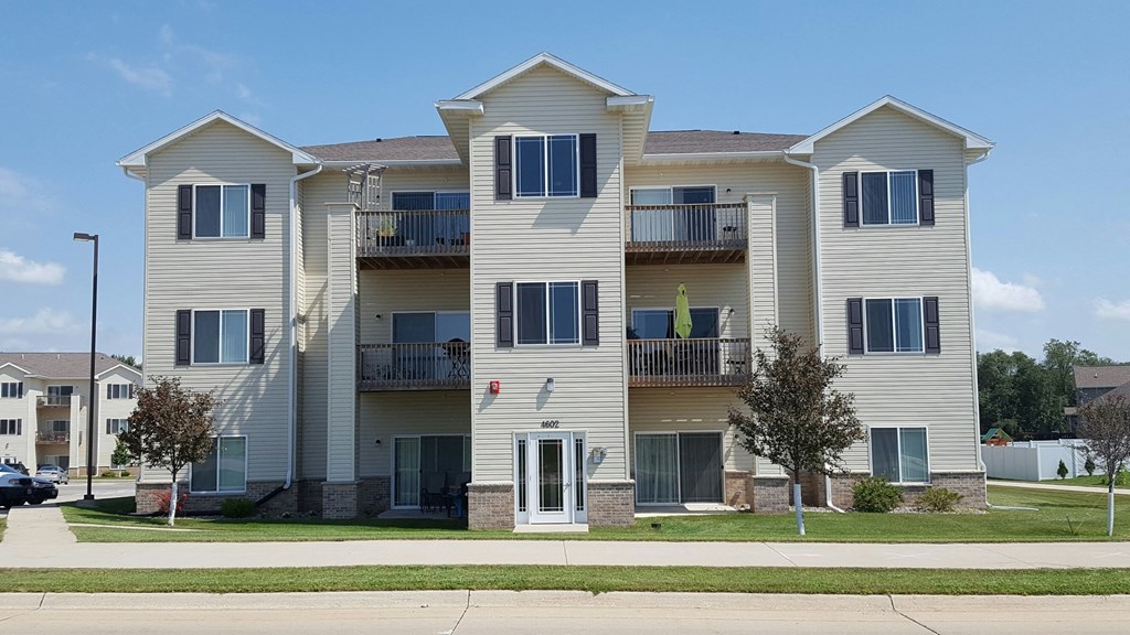an apartment building with tan siding and balconies