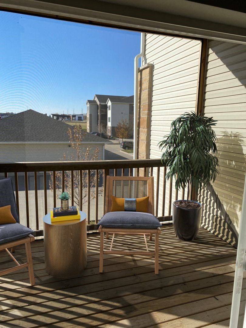 a balcony with two chairs and a table