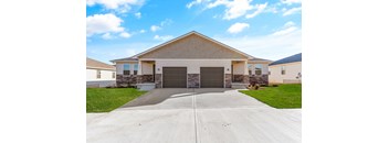 a house with two garage doors in front of a driveway