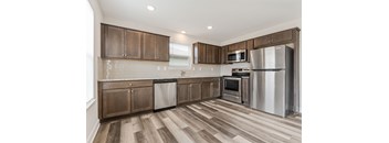 a kitchen with wooden cabinets and stainless steel appliances