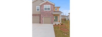 a house with two garage doors on the side of a driveway