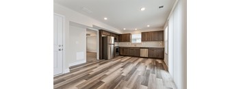 a kitchen with wooden floors and stainless steel appliances