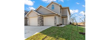 a house with two garage doors and a lawn