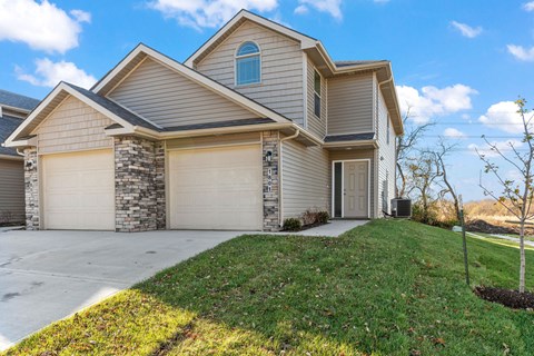 a house with two garage doors and a lawn