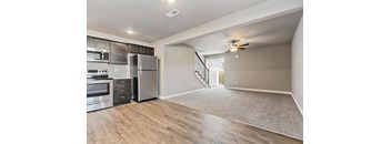 an empty kitchen with stainless steel appliances and a ceiling fan