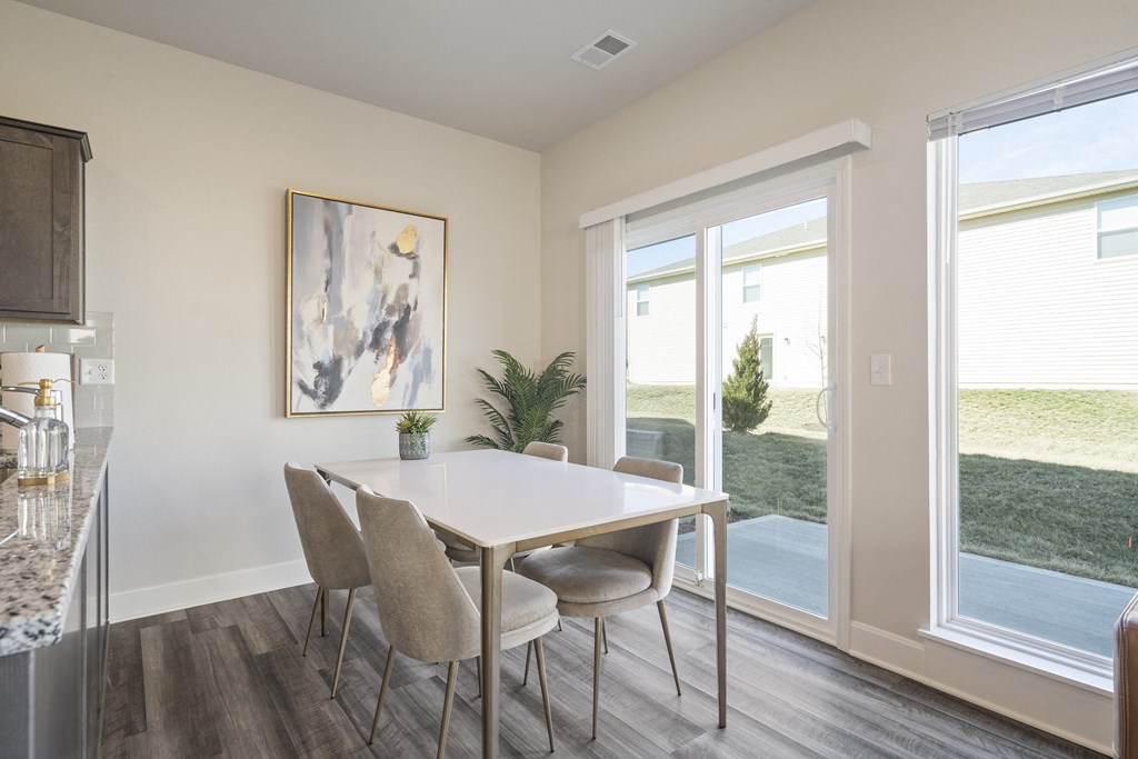 a dining room with a table and chairs and a window