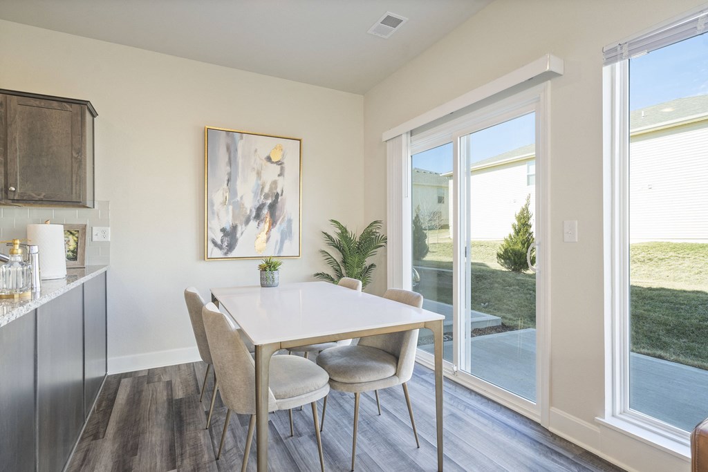 a dining area with a table and chairs and a sliding glass door