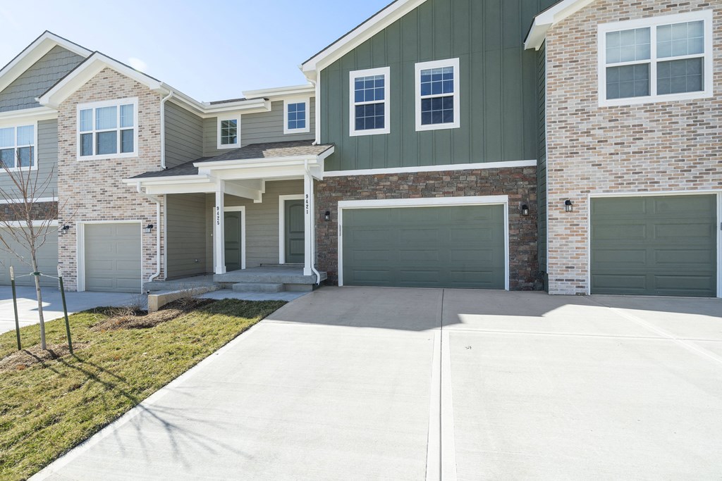 an empty driveway in front of a house with a garage door