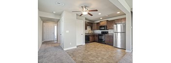 an empty kitchen with stainless steel appliances and a ceiling fan