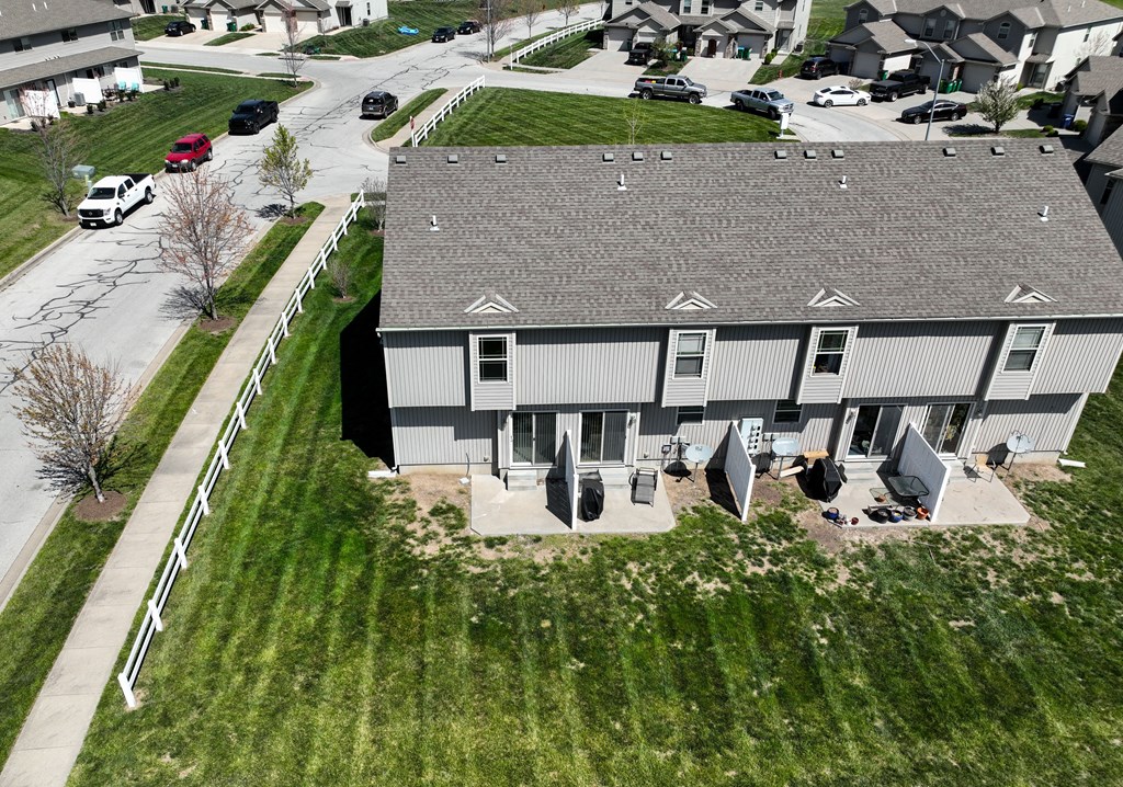 a house with a gray roof and a yard with umbrellas