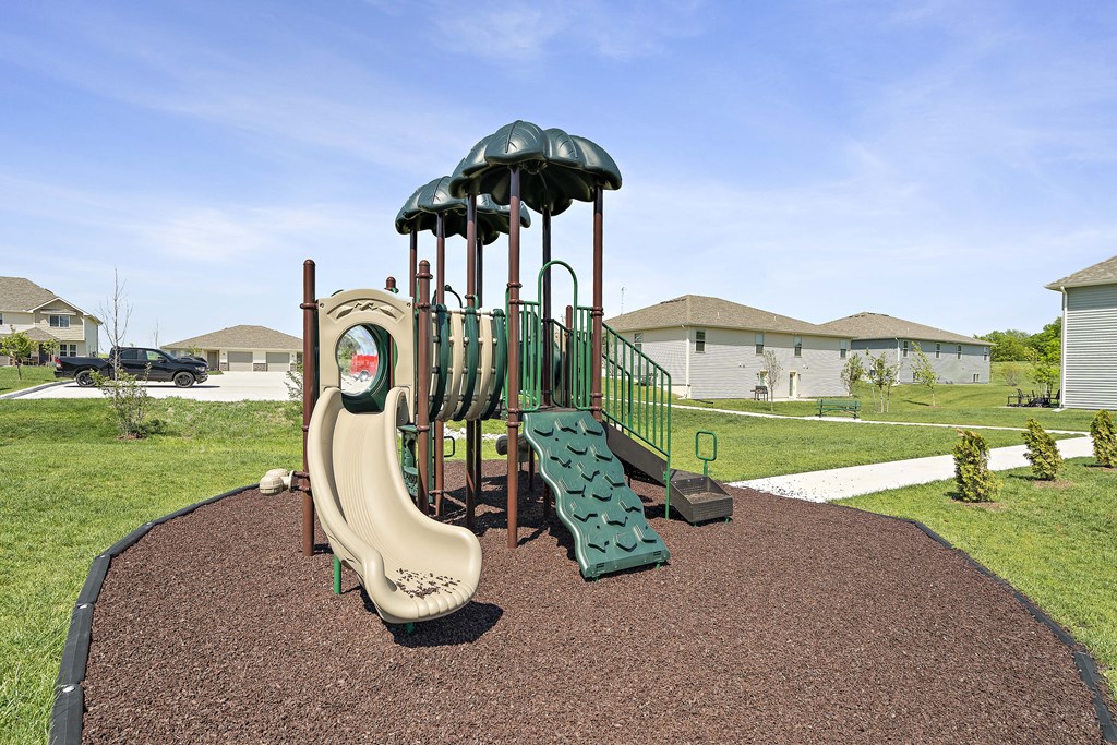 a playground with a slide and climbing equipment in a yard