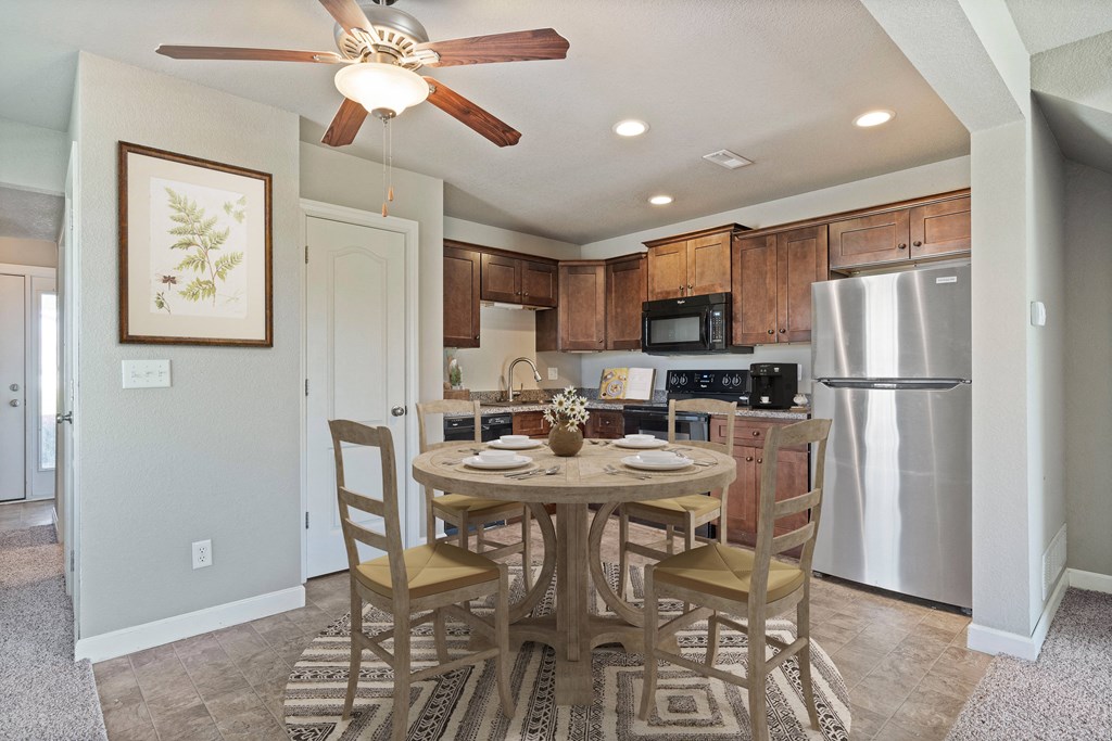 a kitchen with a dining table and a refrigerator
