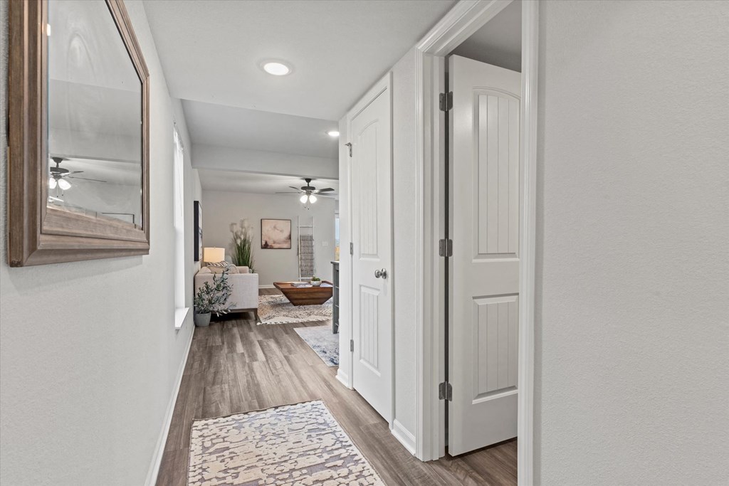 the entrance to a renovated house with white doors and a hallway with a living room