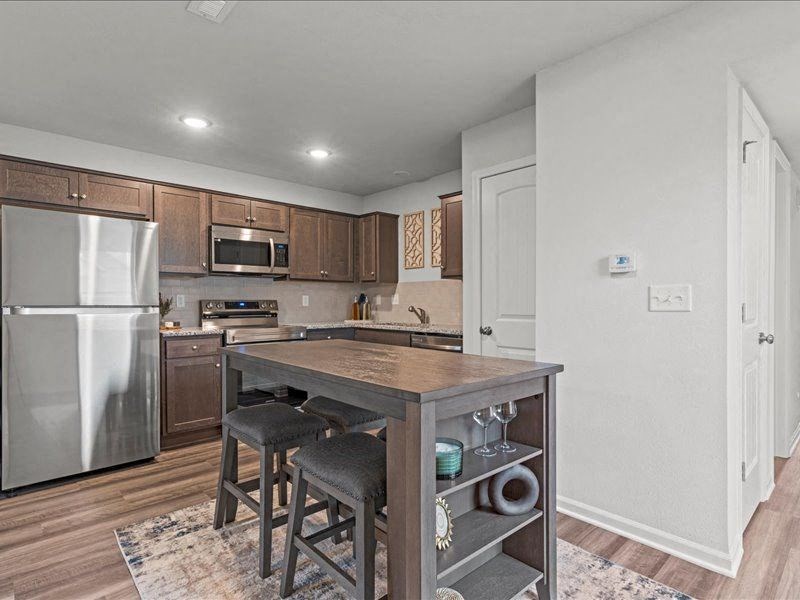 a kitchen with a island and a stainless steel refrigerator