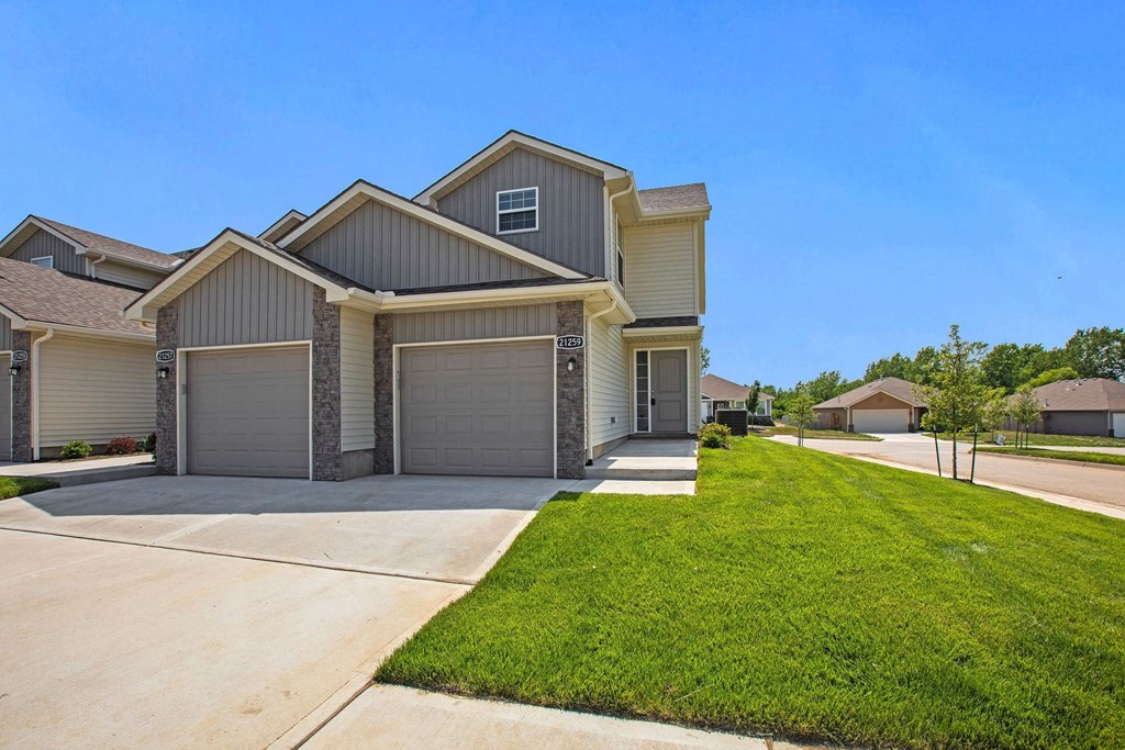 the front of a house with a driveway and a lawn