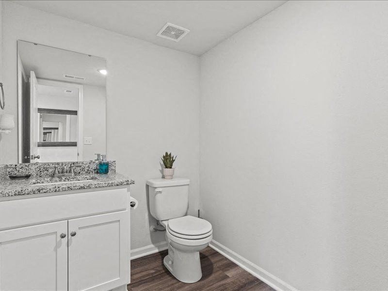 a white bathroom with a toilet and a sink