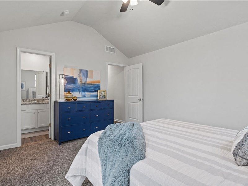 a bedroom with a bed and a blue dresser