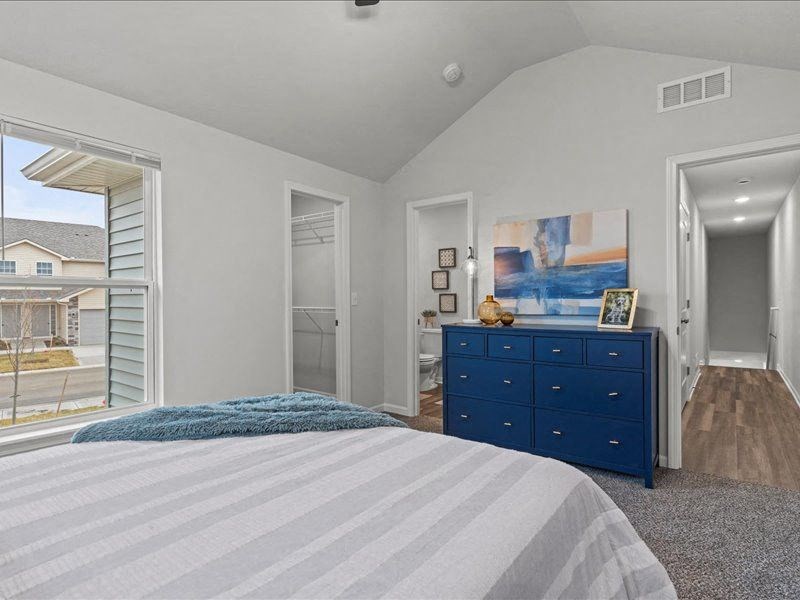 a bedroom with a bed and a blue dresser