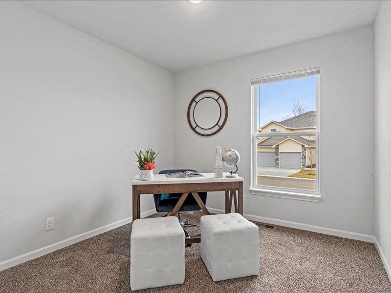 an office with a window and a table and stools