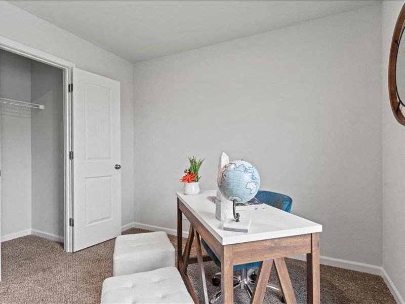 a home office with a desk and chair and a white door