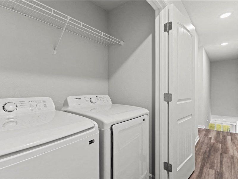 a white laundry room with two washes and a dryer