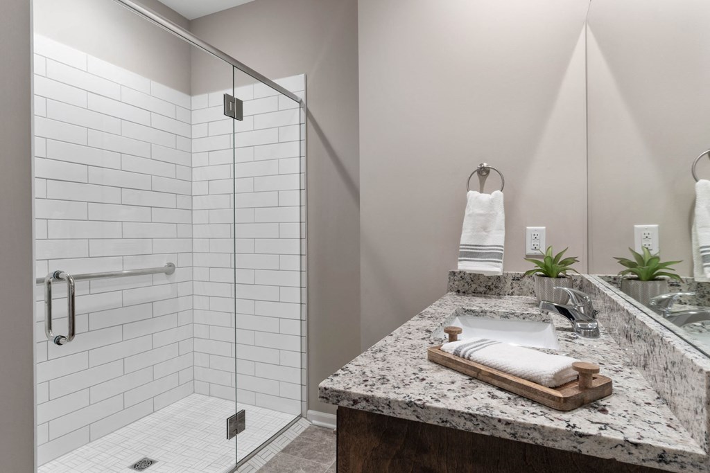 a bathroom with a shower and a sink and a mirror