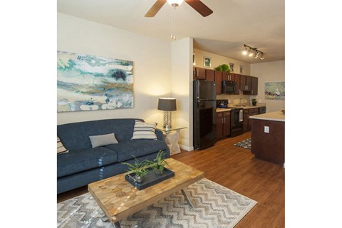 a living room and kitchen with a couch and a table