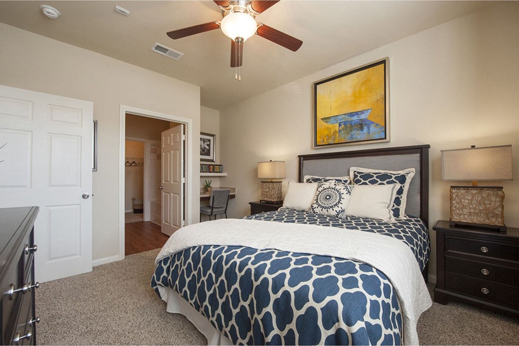 a bedroom with a bed and a ceiling fan