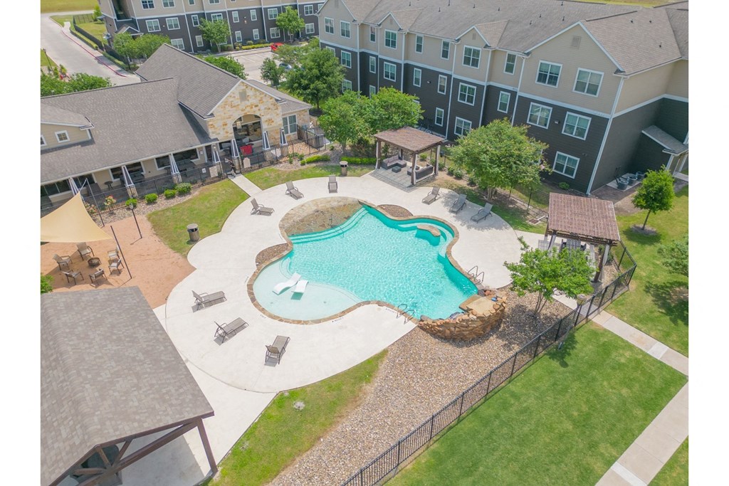an aerial view of an apartment complex with an outdoor pool