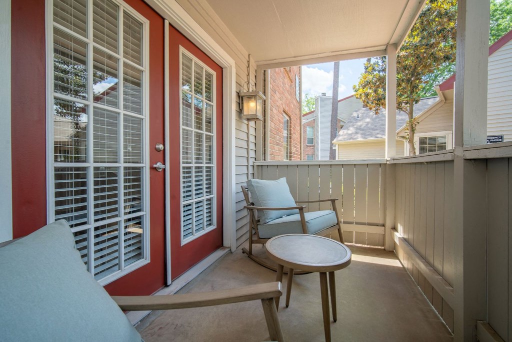 a porch with two chairs and a table