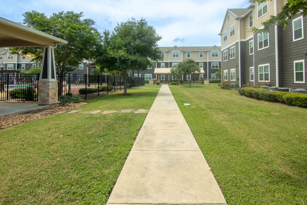 a sidewalk leading to an apartment complex